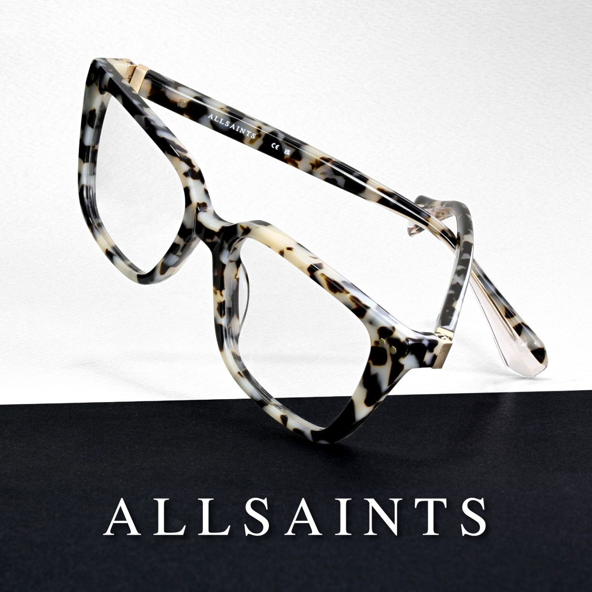 Black and white mottled frames at an angle against a mostly white background, AllSaints logo along the bottom in white text againts a black backround