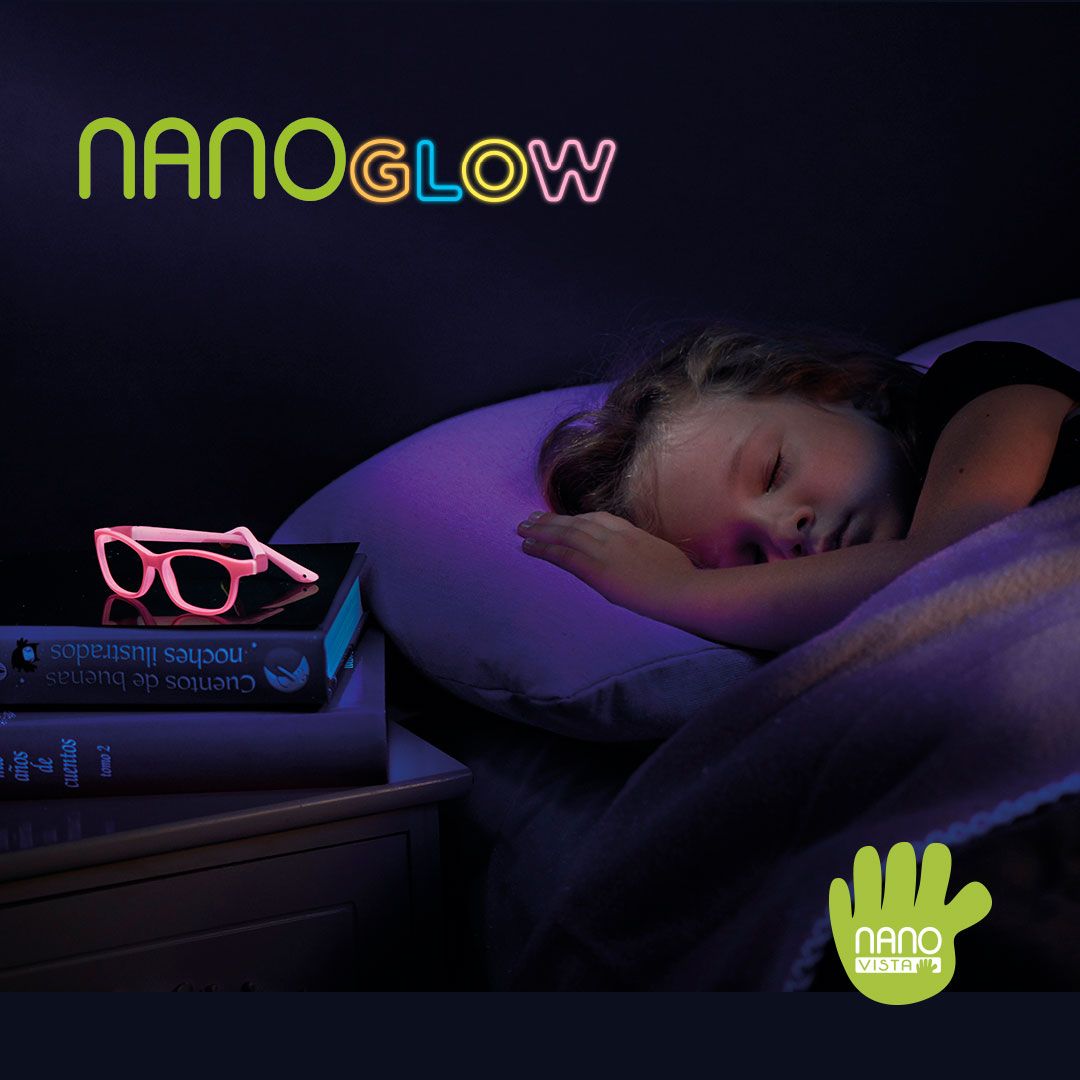 Young girl in bed sleeping in a dark room. A pair of glowing pink frames sit on top of a stack of books on the night stand. Nano Glow logo located in the upper left, Nano Vista logo located on bottom right.