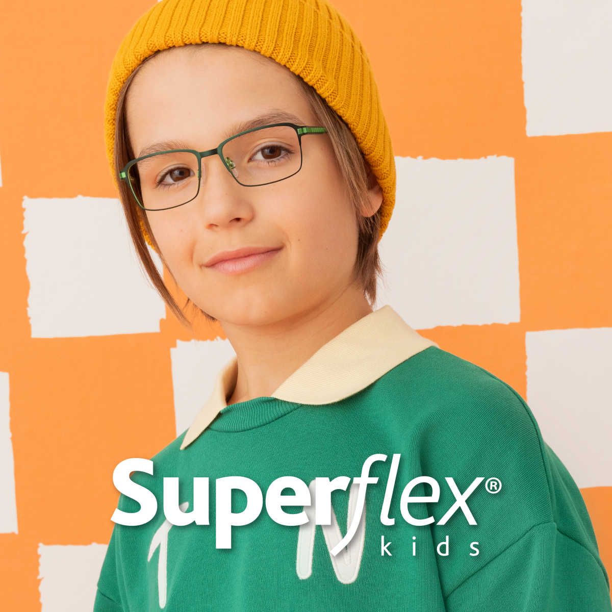 Young child against checkered background wearing green Superflex frames