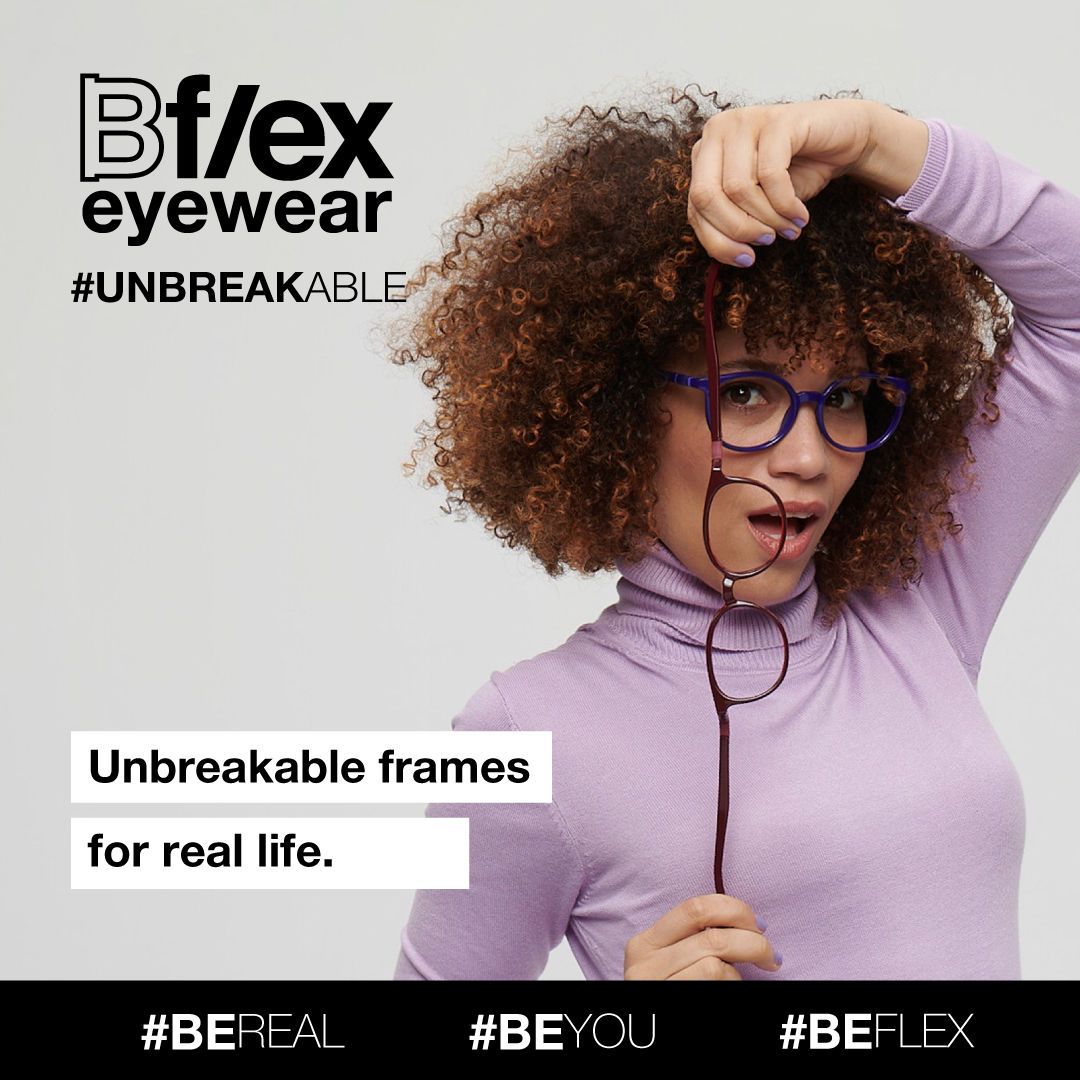 A woman with dark curly hair, wearing a long-sleeved lilac turtle-neck, models thick blue frames, holding and stretching a pair of thick dark purple frames. Bflex Eyewear logo is in the upper left of the image.